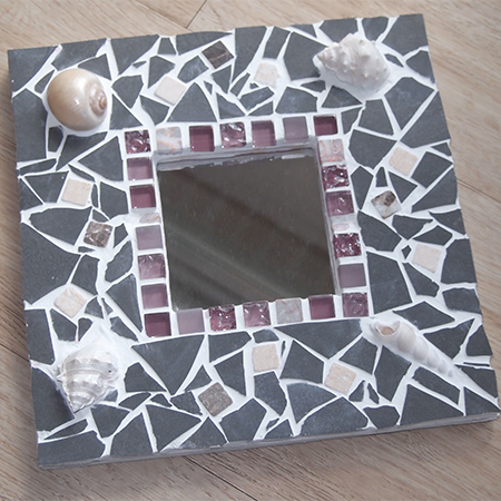 Spiegel mit grauen Fliesen und Muscheln